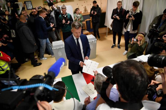 Peter Magyar (C), leader of the pro-European conservative TISZA party, gets his ballot papers at a polling station set up in a kindergarten in Budapest during a general election in Hungary, on April 12, 2026. The vote could end Hungarian Prime Minister Viktor Orban's 16-year stint in power as the EU's longest serving current leader and a self-decribed "thorn" in the bloc's side. (Photo by Ferenc ISZA / AFP)