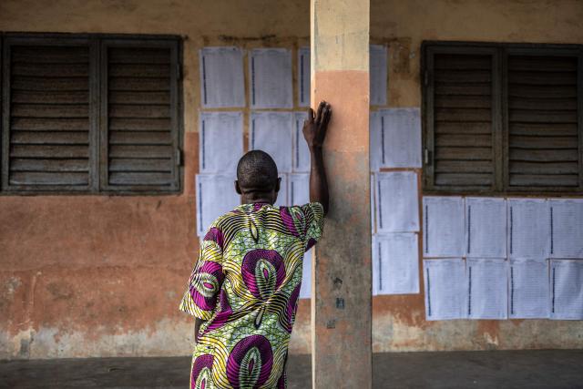 TOPSHOT - A voter looks for his name on the voters’ roll at a primary school serving as a polling station in Cotonou, on April 12, 2026 during Benin's presidential election. (Photo by OLYMPIA DE MAISMONT / AFP)