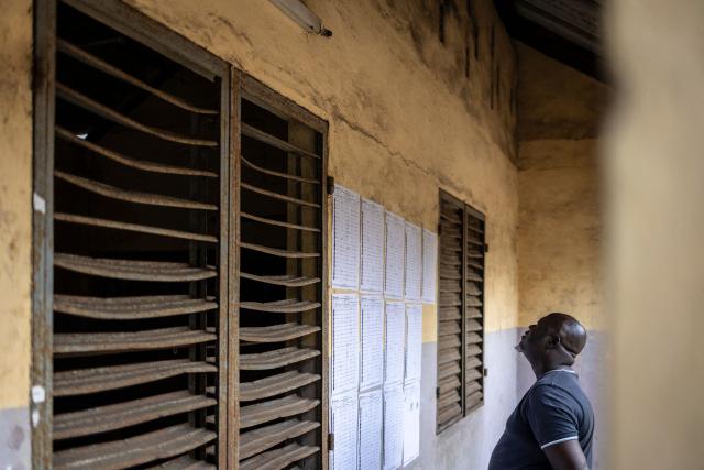 A voter looks for his name on the voters’ roll at a primary school serving as a polling station in Cotonou, on April 12, 2026 during Benin's presidential election. (Photo by OLYMPIA DE MAISMONT / AFP)
