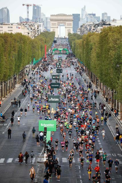 Athletes take the start on the Champs-Elysees avenue during the Paris Marathon, with the Arc de Triomphe in the background, in Paris, on April 12, 2026. (Photo by Ian LANGSDON / AFP)