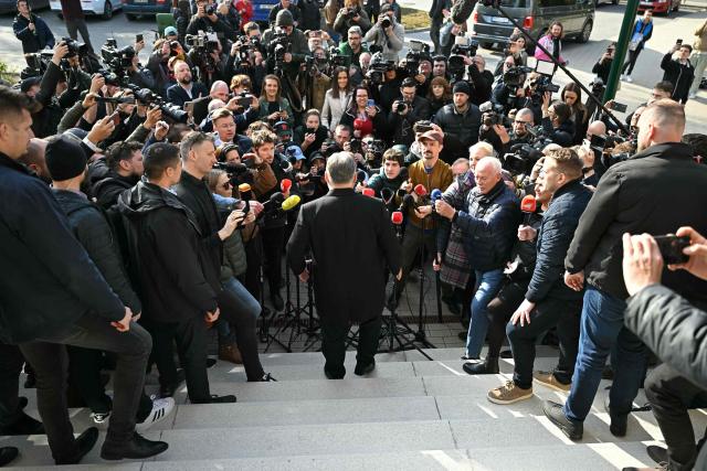 Hungarian Prime Minister Viktor Orban (C) answers journalists' questions after he voted at a polling station set up in a school of the 12th district in Budapest during a general election in Hungary, on April 12, 2026. The vote could end Hungarian Prime Minister Viktor Orban's 16-year stint in power as the EU's longest serving current leader and a self-decribed "thorn" in the bloc's side. (Photo by Attila KISBENEDEK / AFP)