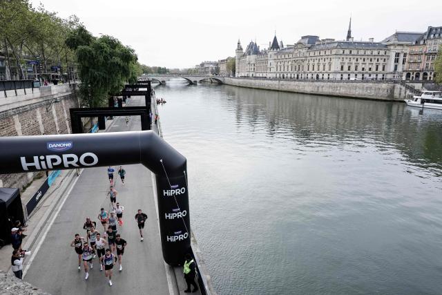Participants run along the docks of the Seine river during the Paris Marathon, in Paris, on April 12, 2026. (Photo by STEPHANE DE SAKUTIN / AFP)
