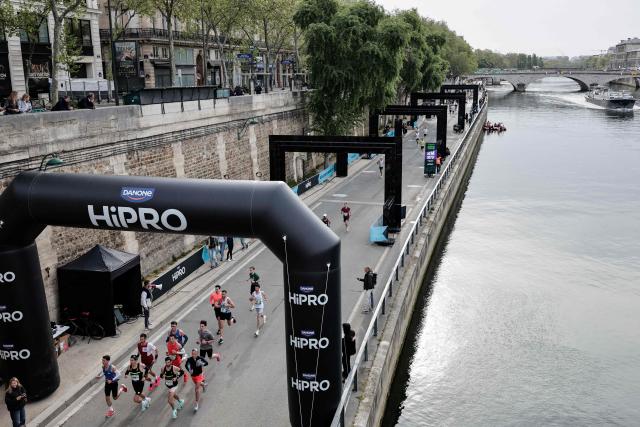 Participants run along the docks of the Seine river during the Paris Marathon, in Paris, on April 12, 2026. (Photo by STEPHANE DE SAKUTIN / AFP)