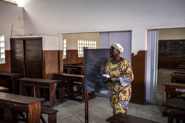 A voter leaves a voting booth before casting her ballot at a primary school serving as a polling station in Cotonou, on April 12, 2026 during Benin's presidential election. (Photo by OLYMPIA DE MAISMONT / AFP)