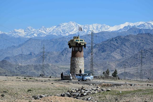 A former US military Humvee with the Taliban flag flying over it is displayed atop a tower in the Naghlu area of Surobi district, Kabul province, on April 12, 2026. (Photo by Wakil KOHSAR / AFP)
