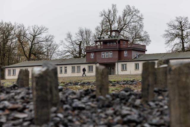 Stele are pictured as the main building of the Buchenwald Nazi concentration camp memorial site is seen in the background on April 12, 2026, prior to the commemoration ceremony to mark the 81th anniversary of the liberation of the Buchenwald Nazi concentration camp at the camp's memorial site near Weimar, eastern Germany. (Photo by JENS SCHLUETER / AFP)