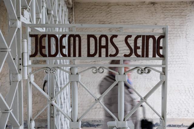 The main gate with the inscription "Jedem das Seine" (To Each His Own) is pictured at the memorial site of the former Nazi concentration camp Buchenwald on April 12, 2026, prior to the commemoration ceremony to mark the 81th anniversary of the liberation of the Buchenwald Nazi concentration camp at the camp's memorial site near Weimar, eastern Germany. From 1937 to 1945, almost 280,000 victims of the Nazis were imprisoned in Buchenwald concentration camp and its satellite camps; more than 56,000 were murdered or died as a result of inhumane conditions. Among the prisoners were Jews, Roma, domestic political opponents of the Nazis, and forced laborers from Eastern Europe. Buchenwald is one of the most symbolically significant and best-known former concentration camps in Germany. (Photo by JENS SCHLUETER / AFP)