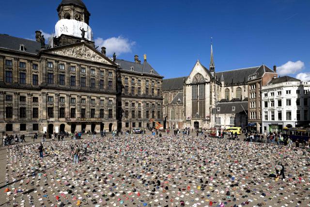 A photo shows children's shoes layed out on Dam Square during a memorial protest organised by Plant an Olive Tree group for child victims in Gaza, in Amsterdam, on April 12, 2026. (Photo by Ramon van Flymen / ANP / AFP) / Netherlands OUT