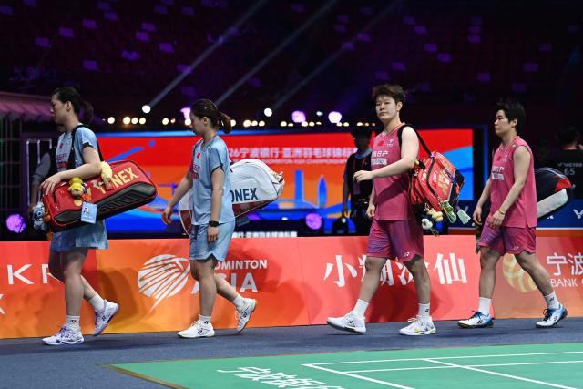 Liu Shengshu (2nd-R) and Tan Ning (R)) of China retire due to injury in their women's doubles final match against Li Yijing (2nd-L) and Luo Xumin (L) of China at the Badminton Asia Championship in Ningbo, in China's eastern Zhejiang province, on April 12, 2026. (Photo by CN-STR / AFP) / China OUT