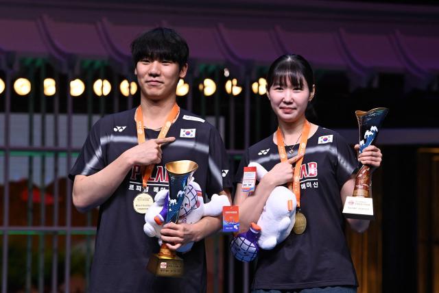 Gold medallists South Korea's Kim Jae-hyeon (L) and Jang Ha-jeong pose with their trophies during the award ceremony for their mixed doubles at the Badminton Asia Championship in Ningbo, eastern China's Zhejiang province on April 12, 2026. Zhejiang Province on April 12, 2026. (Photo by CN-STR / AFP) / China OUT