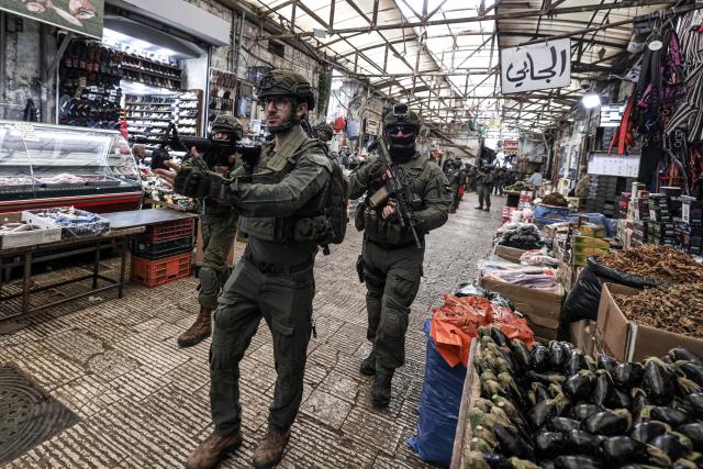 Israeli soldiers patrol through the market in the Old City of Nablus, in the northern Israeli-occupied Palestinian West Bank on April 12, 2026. Israeli police said on April 12, eight suspects were arrested after an overnight attack by Israeli civilians on a Palestinian village in the occupied West Bank. Violence in the West Bank, which Israel has occupied since 1967, has risen sharply since the October 7, 2023 Hamas attack on Israel triggered the Gaza war. (Photo by JAAFAR ASHTIYEH / AFP)