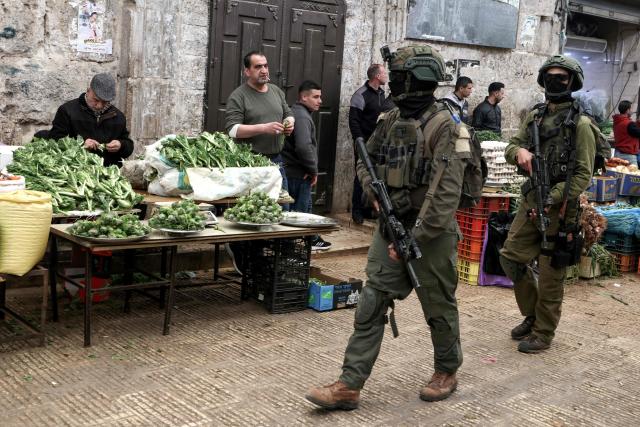 Israeli soldiers patrol through the market in the Old City of Nablus, in the northern Israeli-occupied Palestinian West Bank on April 12, 2026. Israeli police said on April 12, eight suspects were arrested after an overnight attack by Israeli civilians on a Palestinian village in the occupied West Bank. Violence in the West Bank, which Israel has occupied since 1967, has risen sharply since the October 7, 2023 Hamas attack on Israel triggered the Gaza war. (Photo by JAAFAR ASHTIYEH / AFP)
