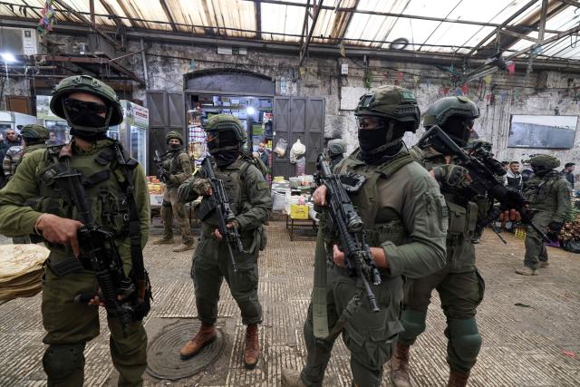 Israeli soldiers patrol the market in the Old City of Nablus, in the northern Israeli-occupied West Bank on April 12, 2026. Israeli police said on April 12, eight suspects were arrested after an overnight attack by Israeli civilians on a Palestinian village in the occupied West Bank. Violence in the West Bank, which Israel has occupied since 1967, has risen sharply since the October 7, 2023 Hamas attack on Israel triggered the Gaza war. (Photo by JAAFAR ASHTIYEH / AFP)