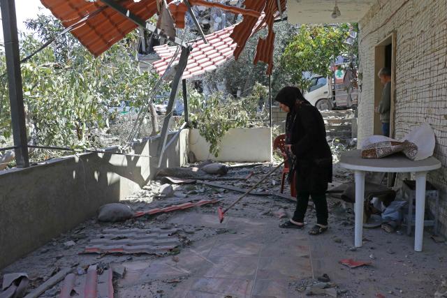 A woman clears the debris from her house damaged by an Israeli strike that targeted the southern Lebanese village of Al-Bazouriyah, on April 12, 2026. Lebanese authorities said on April 11 that Israeli strikes have killed 2,020 people since the start of the war between Israel and Iran-backed Hezbollah last month. (Photo by Kawnat HAJU / AFP)