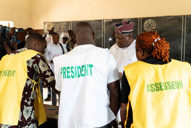 Presidential candidate Paul Hounkpe (2nd R) speaks to electoral officials after casting his ballot at a polling station in Lobogo on April 12, 2026 during Benin's presidential election. (Photo by Yanick Folly / AFP)
