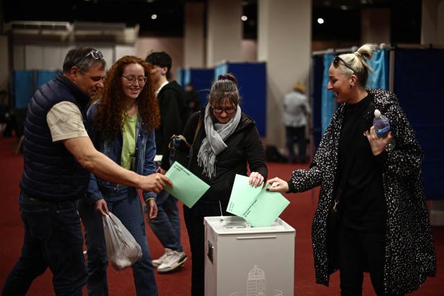 Voters cast their ballots in the Hungarian election inside the polling station set up at a hotel in west London, on April 12, 2026. The vote could end Hungarian Prime Minister Viktor Orban's 16-year stint in power as the EU's longest serving current leader and a self-decribed "thorn" in the bloc's side. (Photo by Henry NICHOLLS / AFP)