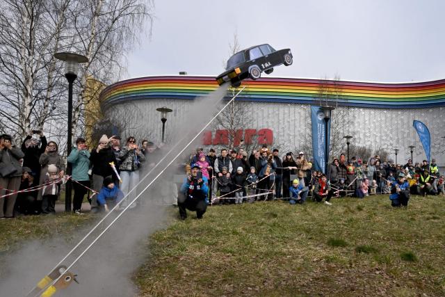 Attendees watch the launch of a model Soviet car during celebrations marking the 65th anniversary of Russia's Yuri Gagarin's first manned flight into space in Saint Petersburg on April, 12, 2026. (Photo by Olga MALTSEVA / AFP)