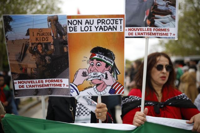 A person holds a placard reading "No to the Yadan bill" as protesters take part in a rally against the Yadan bill, which aims to combat new forms of anti-Semitism, in Paris on April 12, 2026. The proposed bill, named after French lawmaker from the presidential camp Caroline Yadan and will be debated next April 16 and 17, aims to combat "new forms" of anti-Semitism and has met with strong reservations. Its opponents, particularly on the left, argue that it would threaten freedom of expression and perpetuate a conflation of Jews and Israel. (Photo by Ian LANGSDON / AFP)