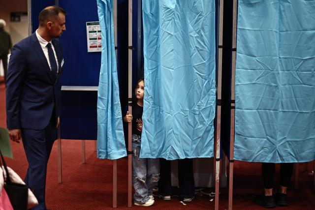 Voters use the polling booths as they vote in the Hungarian election inside the polling station set up at a hotel in west London, on April 12, 2026. The vote could end Hungarian Prime Minister Viktor Orban's 16-year stint in power as the EU's longest serving current leader and a self-decribed "thorn" in the bloc's side. (Photo by Henry NICHOLLS / AFP)