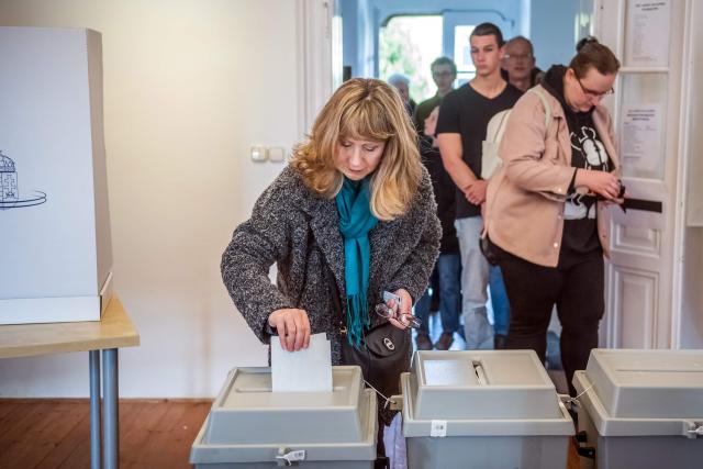 A voter casts her ballot for the general election at a polling station in Piliscsaba, 35 km from Budapest, on April 12, 2026. Turnout in Hungary's closely watched parliamentary polls on April 12 hit a record 54 percent at midday, election authorities said, as voters flocked to participate in a ballot that could end nationalist Prime Minister Orban's 16-year rule. (Photo by Ferenc ISZA / AFP)
