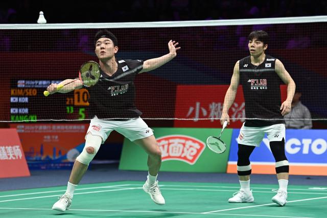 South Korea´s Kang Min-hyuk (L) and Ki Dong-ju hit a return to South Korea´s Kim Won-ho and Seo Seung-jae during their men's doubles final match at the Badminton Asia Championship in Ningbo, eastern China's Zhejiang province on April 12, 2026. (Photo by CN-STR / AFP) / China OUT