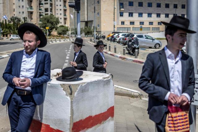 Ultra-Orthodox Jews, who are largely exempt from military service, protest against conscription at the entrance to Tel Hashomer, the central recruitment centre of the Israeli Army, in Ramat-Gan on April 12, 2026. Israel’s Prime Minister, who depends on his ultra-Orthodox party allies to maintain power, has employed a range of tactics to delay the adoption of legislation that would allow the enlistment of ultra-Orthodox Jews, who are largely exempt from military service. Under a ruling established at the country’s creation in 1948—when the ultra-Orthodox community was small—men who devote themselves full-time to the study of sacred Jewish texts receive a de facto exemption. (Photo by Ilia YEFIMOVICH / AFP) / 