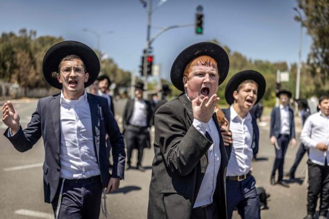 Ultra-Orthodox Jews, who are largely exempt from military service, protest against conscription at the entrance to Tel Hashomer, the central recruitment centre of the Israeli Army, in Ramat-Gan on April 12, 2026. Israel’s Prime Minister, who depends on his ultra-Orthodox party allies to maintain power, has employed a range of tactics to delay the adoption of legislation that would allow the enlistment of ultra-Orthodox Jews, who are largely exempt from military service. Under a ruling established at the country’s creation in 1948—when the ultra-Orthodox community was small—men who devote themselves full-time to the study of sacred Jewish texts receive a de facto exemption. (Photo by Ilia YEFIMOVICH / AFP) / 