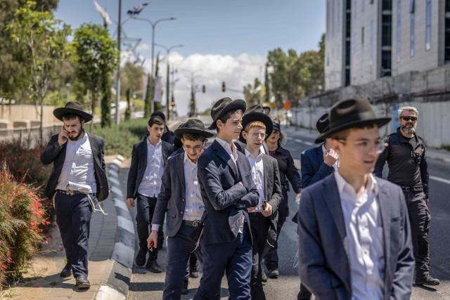 Ultra-Orthodox Jews, who are largely exempt from military service, gather during a protest against conscription at the entrance to Tel Hashomer, the central recruitment centre of the Israeli Army, in Ramat-Gan on April 12, 2026. Israel’s Prime Minister, who depends on his ultra-Orthodox party allies to maintain power, has employed a range of tactics to delay the adoption of legislation that would allow the enlistment of ultra-Orthodox Jews, who are largely exempt from military service. Under a ruling established at the country’s creation in 1948—when the ultra-Orthodox community was small—men who devote themselves full-time to the study of sacred Jewish texts receive a de facto exemption. (Photo by Ilia YEFIMOVICH / AFP) / 