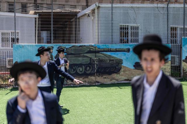 Ultra-Orthodox Jews, who are largely exempt from military service, gather during a protest against conscription at the entrance to Tel Hashomer, the central recruitment centre of the Israeli Army, in Ramat-Gan on April 12, 2026. Israel’s Prime Minister, who depends on his ultra-Orthodox party allies to maintain power, has employed a range of tactics to delay the adoption of legislation that would allow the enlistment of ultra-Orthodox Jews, who are largely exempt from military service. Under a ruling established at the country’s creation in 1948—when the ultra-Orthodox community was small—men who devote themselves full-time to the study of sacred Jewish texts receive a de facto exemption. (Photo by Ilia YEFIMOVICH / AFP) / 