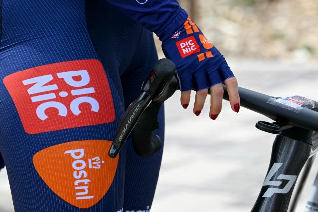 A rider holds her bike prior to the start of the 6th edition of the Women Paris-Roubaix one-day classic cycling race, 143.1 km between Denain and Roubaix, northern France, on April 12, 2026. (Photo by NICOLAS TUCAT / AFP)