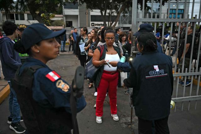 Electoral authorities and police authorize teh entrance of members of the National Jury of Elections in Lima on April 12, 2026 during general elections. Peruvians will elect a new president from a record field of 35 candidates to lead a country plagued by organized crime and chronic political instability. (Photo by Luis ROBAYO / AFP)