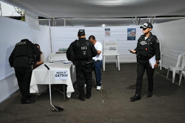 Police check a polling station before its opening in Lima on April 12, 2026, during general elections. Peruvians will elect a new president from a record field of 35 candidates to lead a country plagued by organized crime and chronic political instability. (Photo by Luis ROBAYO / AFP)