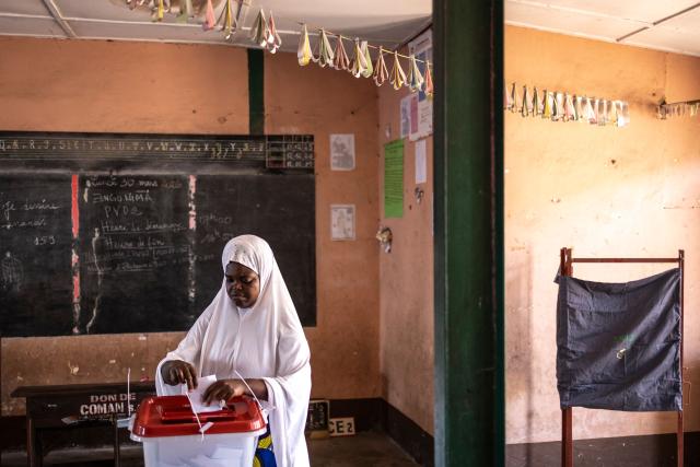A voter casts her ballot at a primary school serving as a polling station in Cotonou, on April 12, 2026 during Benin's presidential election. (Photo by OLYMPIA DE MAISMONT / AFP)