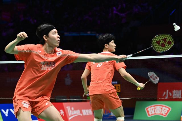 South Korea´s Kim Won-ho (R) and Seo Seung-jae hit a return to South Korea´s Kang Min-hyuk and Ki Dong-ju during their men's doubles final match at the Badminton Asia Championship in Ningbo, eastern China's Zhejiang province on April 12, 2026. (Photo by CN-STR / AFP) / China OUT