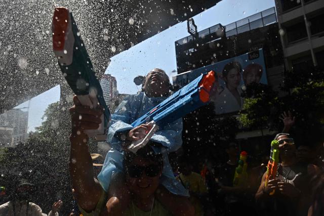 Revellers take part in mass water fights on the eve of the Songkran, or Thai New Year, on Silom Road in Bangkok on April 12, 2026. (Photo by Lillian SUWANRUMPHA / AFP)