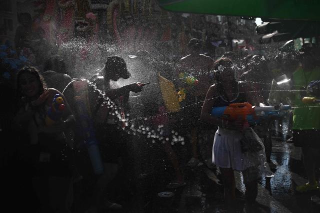 Revellers take part in mass water fights on the eve of the Songkran, or Thai New Year, on Khao San Road in Bangkok on April 12, 2026. (Photo by Lillian SUWANRUMPHA / AFP)
