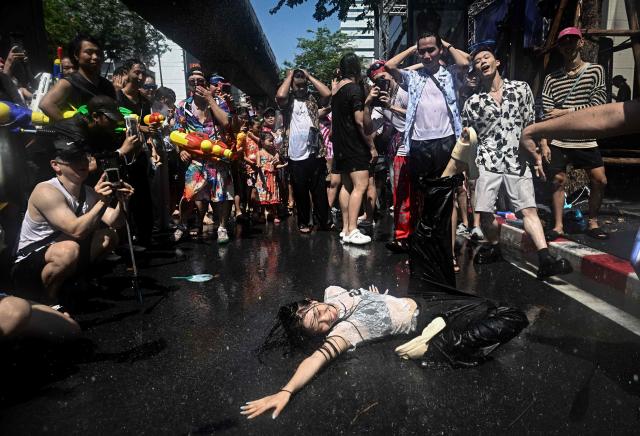 Revellers dance on the street on the eve of the Songkran, or Thai New Year, on Silom Road in Bangkok on April 12, 2026. (Photo by Lillian SUWANRUMPHA / AFP)