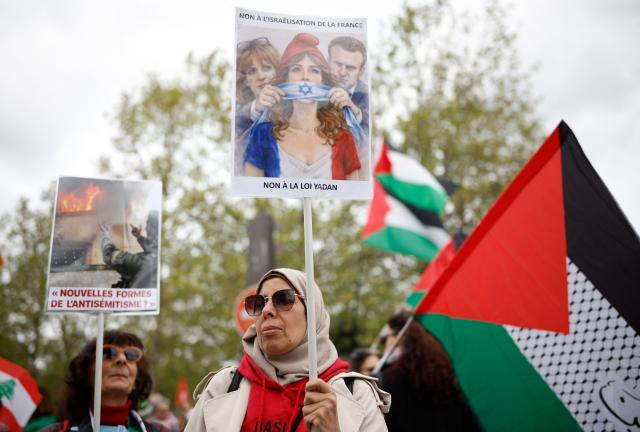 A person holds a placard reading "No to the Yadan bill" as protesters take part in a rally against the Yadan bill, which aims to combat new forms of anti-Semitism, in Paris on April 12, 2026. The proposed bill, named after French lawmaker from the presidential camp Caroline Yadan and will be debated next April 16 and 17, aims to combat "new forms" of anti-Semitism and has met with strong reservations. Its opponents, particularly on the left, argue that it would threaten freedom of expression and perpetuate a conflation of Jews and Israel. (Photo by Ian LANGSDON / AFP)