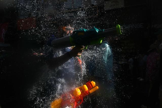 Revellers take part in mass water fights on the eve of the Songkran, or Thai New Year, on Khao San Road in Bangkok on April 12, 2026. (Photo by Lillian SUWANRUMPHA / AFP)