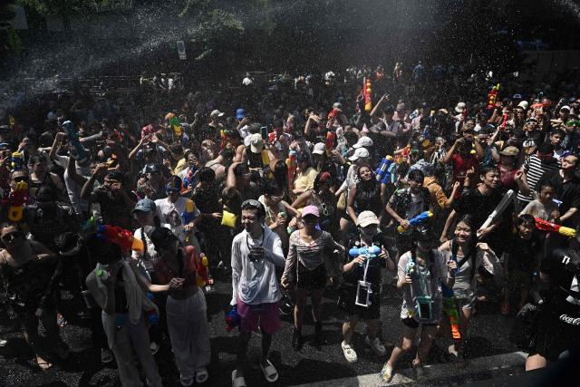 Revellers take part in mass water fights on the eve of the Songkran, or Thai New Year, on Silom Road in Bangkok on April 12, 2026. (Photo by Lillian SUWANRUMPHA / AFP)