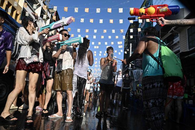 Revellers take part in mass water fights on the eve of the Songkran, or Thai New Year, on Khao San Road in Bangkok on April 12, 2026. (Photo by Lillian SUWANRUMPHA / AFP)