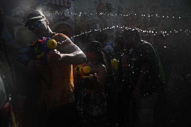 Revellers take part in mass water fights on the eve of the Songkran, or Thai New Year, on Khao San Road in Bangkok on April 12, 2026. (Photo by Lillian SUWANRUMPHA / AFP)