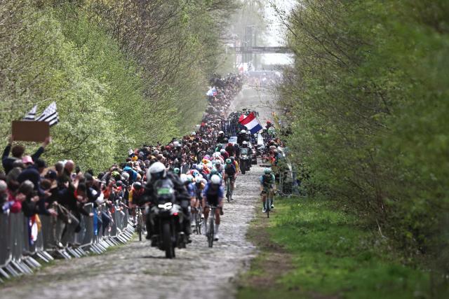 The leading pack rides on the 'Trouйe d’Arenberg' cobblestone sector (Arenberg trench) during the 123rd edition of the Paris-Roubaix one-day classic cycling race, 258.3 km between Compiиgne and Roubaix, northern France, on April 12, 2026. (Photo by Anne-Christine POUJOULAT / AFP)