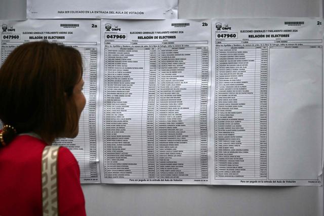 A woman looks for her name on a list to find where to vote, in Lima on April 12, 2026, during general elections. Peruvians will elect a new president from a record field of 35 candidates to lead a country plagued by organized crime and chronic political instability. (Photo by Luis ROBAYO / AFP)