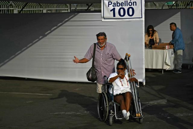 Voters look for their corresponding polling station in Lima on April 12, 2026, during general elections. Peruvians will elect a new president from a record field of 35 candidates to lead a country plagued by organized crime and chronic political instability. (Photo by Luis ROBAYO / AFP)