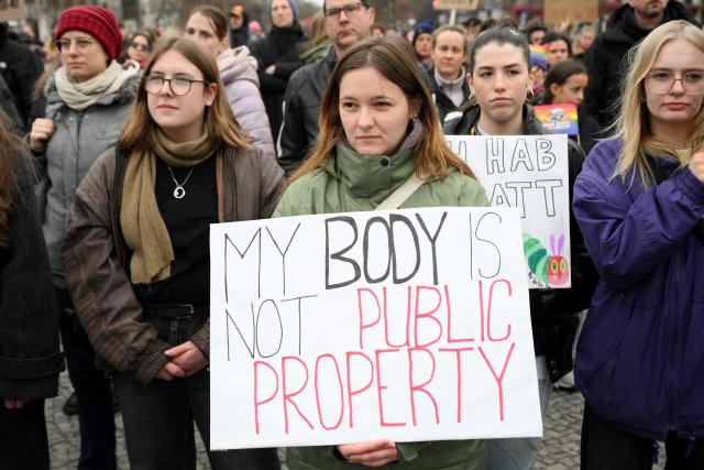 Participants hold up a placard with the lettering reading 'My body is not public property' during a demonstration against sexualized violence against women in Berlin on April 12, 2026. A feminist alliance has called for the demonstration, which is also held in support of German TV presenter and actress Collien Fernandes and all those affected to show: "Enough is enough! Stop the violence against women". The allegations from Fernandes against her ex-husband, actor Christian Ulmen, have sparked intense media debate about the "digital violence" increasingly perpetrated on the internet, mostly against women. The German government has responded to the outcry by pledging to introduce laws to punish the creation and distribution of sexualised deepfakes. (Photo by RALF HIRSCHBERGER / AFP)
