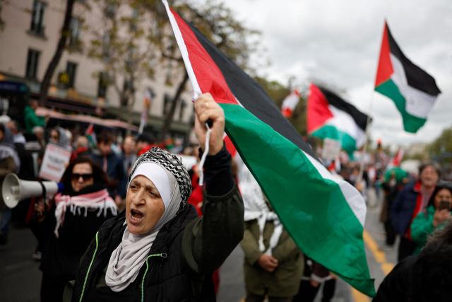 A woman holds a Palestinian flag during a rally against the Yadan bill, which aims to combat new forms of anti-Semitism, in Paris on April 12, 2026. The proposed bill, named after French lawmaker from the presidential camp Caroline Yadan and will be debated next April 16 and 17, aims to combat "new forms" of anti-Semitism and has met with strong reservations. Its opponents, particularly on the left, argue that it would threaten freedom of expression and perpetuate a conflation of Jews and Israel. (Photo by Ian LANGSDON / AFP)