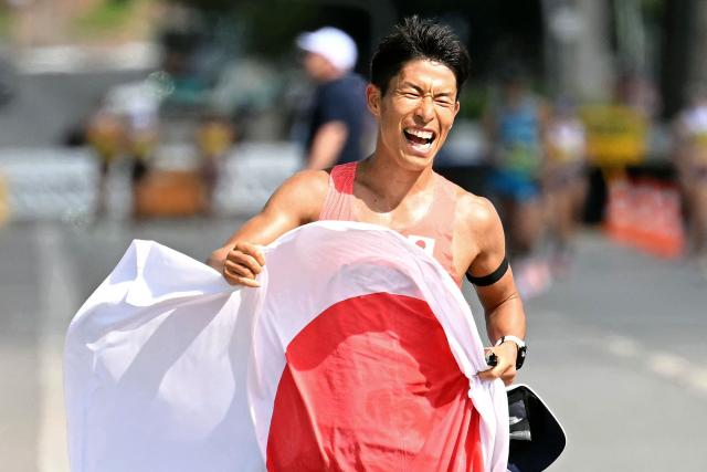 Japan's Hayato Katsuki celebrates with the national flag after winning the World Athletics Race Walking Team Championships men's marathon, in Brasilia, on April 12, 2026. (Photo by Evaristo SA / AFP)