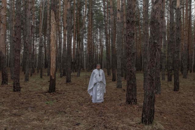 Priest Petro Nemesh prays with Ukrainian military members of the 33rd separate mechanised brigade to celebrate Orthodox Easter, in the Kharkiv region, on April 12, 2026, amid the Russian invasion of Ukraine. (Photo by Roman PILIPEY / AFP)