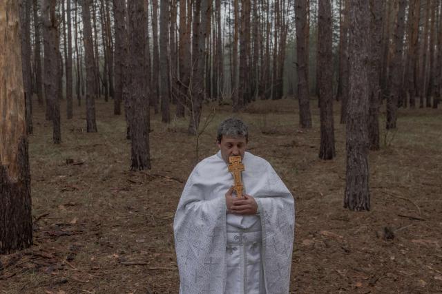 TOPSHOT - Priest Petro Nemesh prays with Ukrainian military members of the 33rd separate mechanised brigade to celebrate Orthodox Easter, in the Kharkiv region, on April 12, 2026, amid the Russian invasion of Ukraine. (Photo by Roman PILIPEY / AFP)